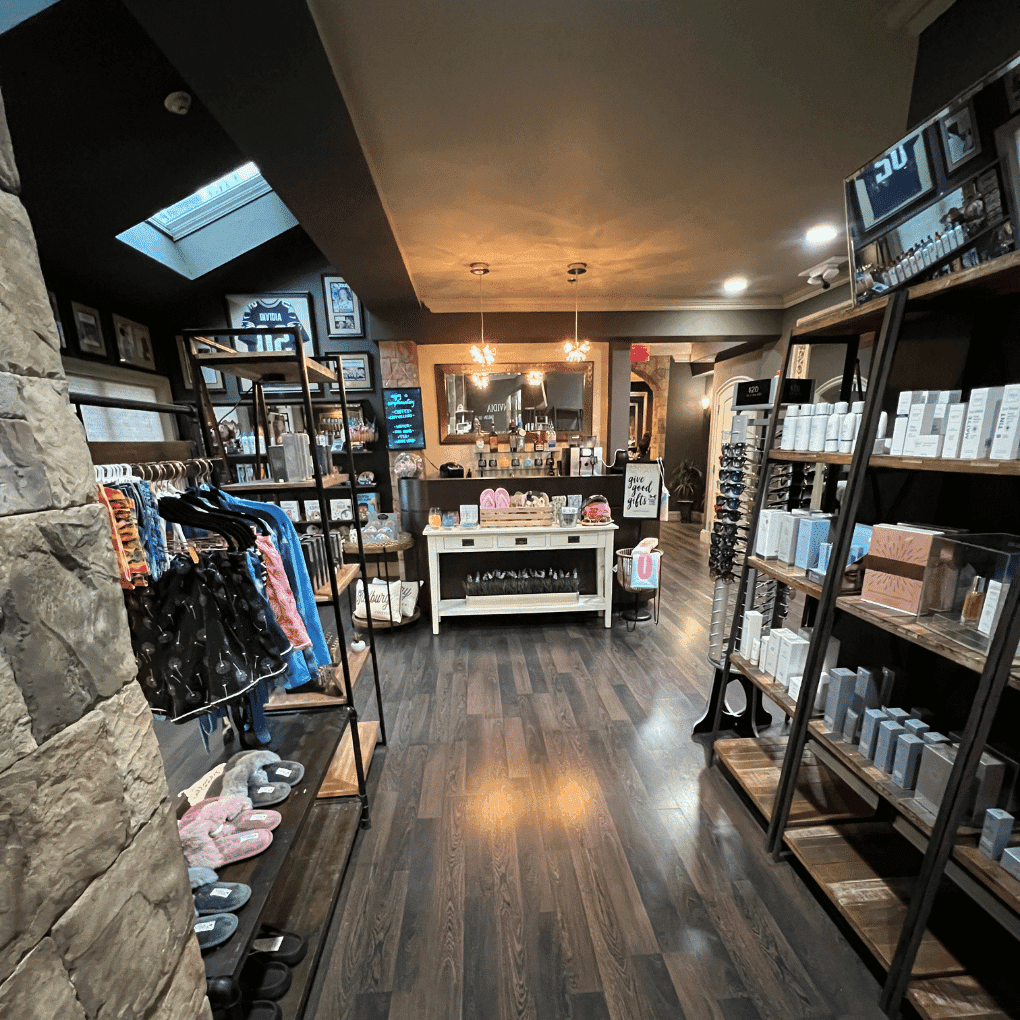 Cozy boutique with clothing, skincare products, and elegant lighting on wooden flooring.