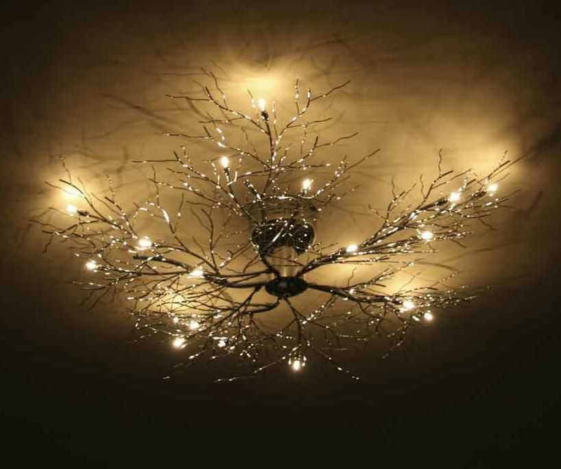 Ceiling light with branches and warm glowing bulbs creating an artistic, elegant ambiance.