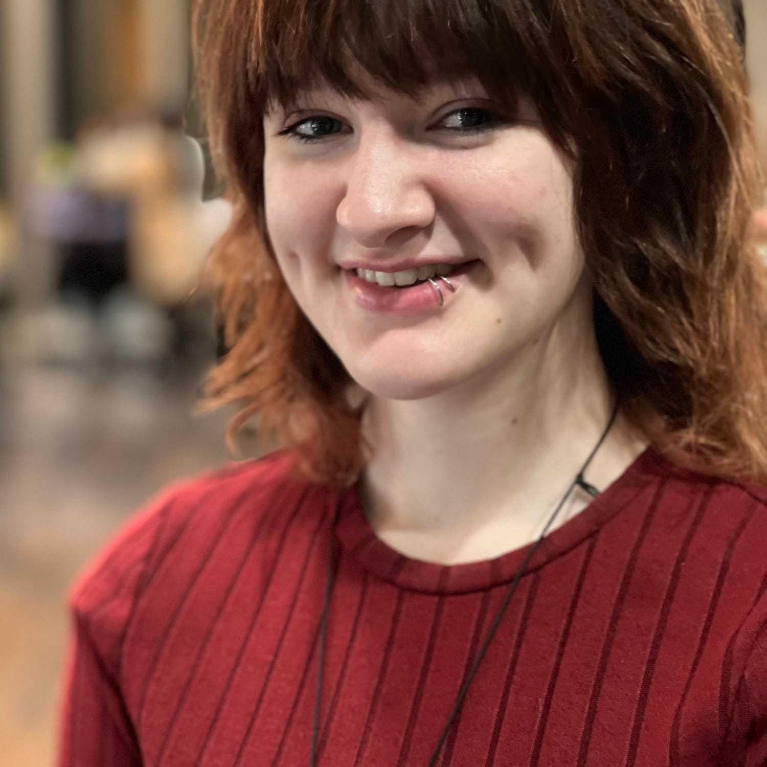 Portrait of Arabella, a professional stylist at Invidia Salon and Spa, showcasing their expertise and style.