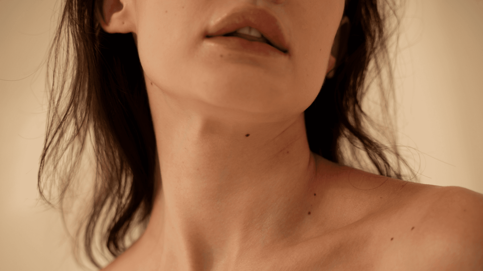 Close-up of a woman's face and neck with beauty marks.