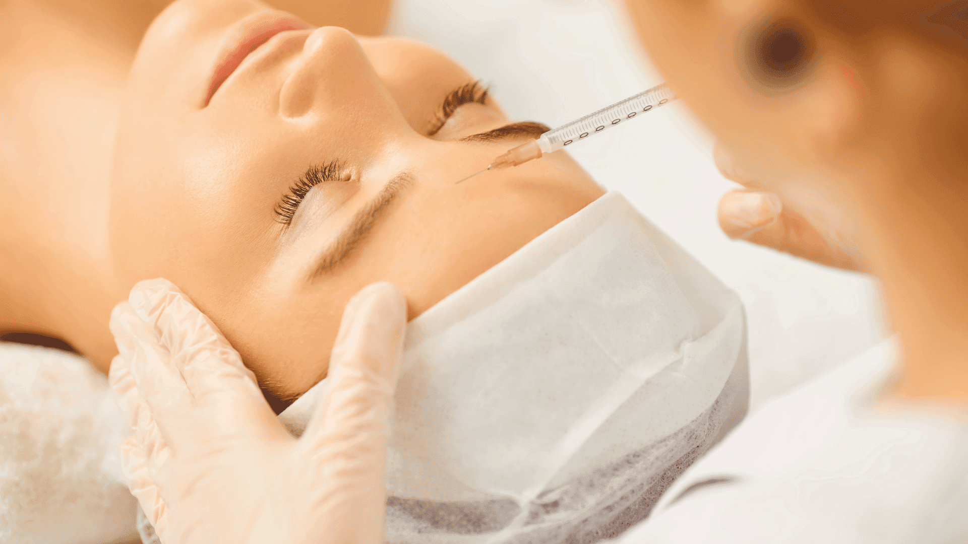 Aesthetician administering facial injection to a relaxed patient in spa.